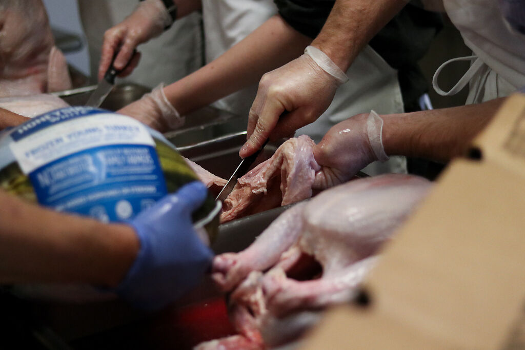Drew Anderson slices in to the loose skin of a turkey